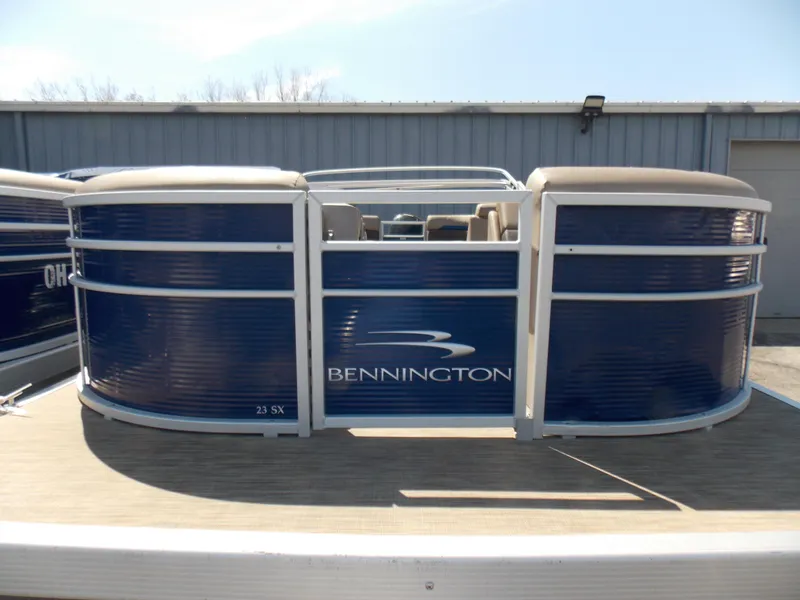 Slide: The Image of 2022 Bennington SX 23 Quad Bench pontoon boat with blue exterior, docked outdoors. - 4