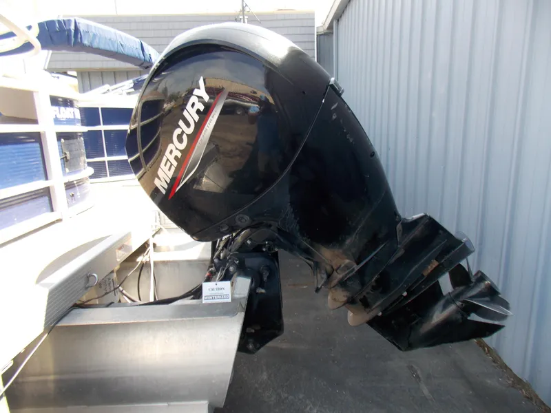 Slide: The Image of 2022 Bennington SX 23 Quad Bench with Mercury outboard motor, docked beside a building. - 6