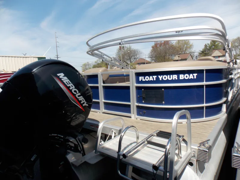 Slide: The Image of 2022 Bennington SX 23 Quad Bench pontoon boat with Mercury engine, docked under clear sky. - 7