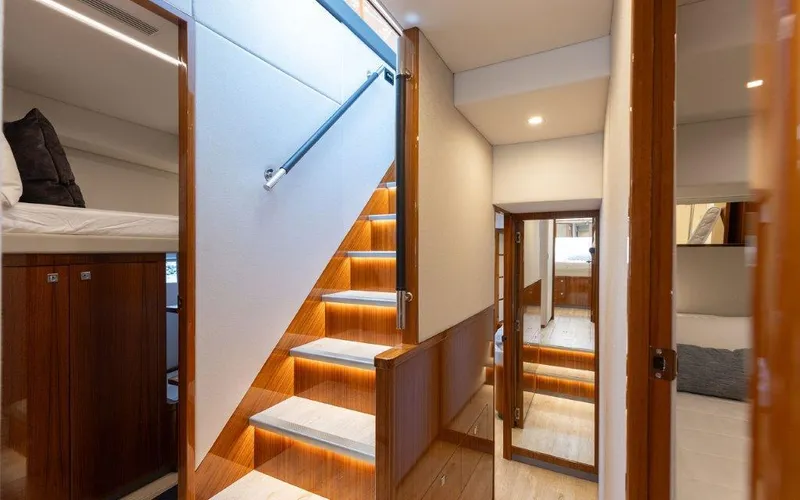 Slide: The Image of Luxurious interior of 2022 Riviera 645 SUV yacht with modern staircase and elegant wood finishes. - 19