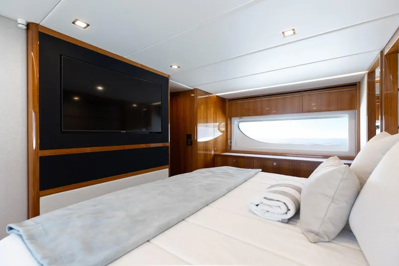 Slide: The Image of Luxurious bedroom interior of 2022 Riviera 645 SUV yacht with large TV and window view. - 21