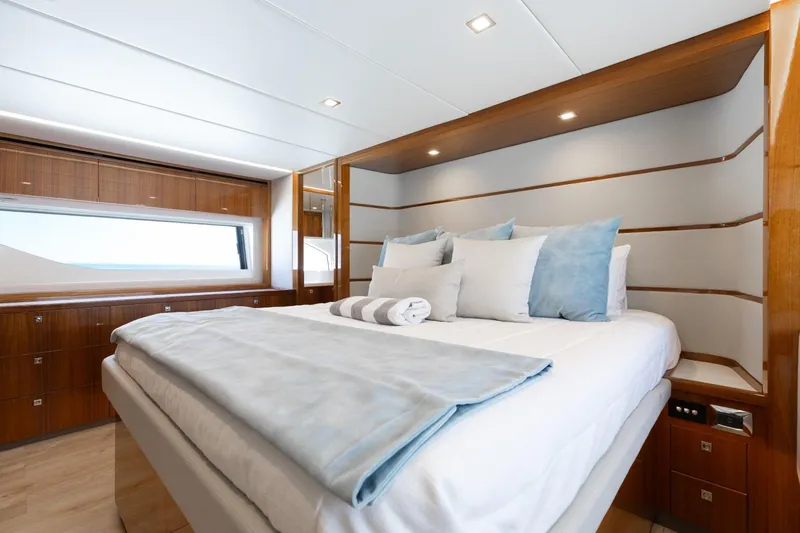 Slide: The Image of Luxurious bedroom interior of 2022 Riviera 645 SUV yacht with elegant bedding and wood accents. - 22