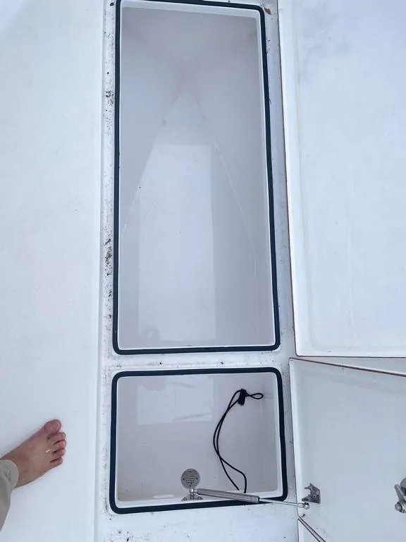 Slide: The Image of 2019 Onslow Bay 33 Tournament boat storage compartments, open and empty, with visible wiring. - 11