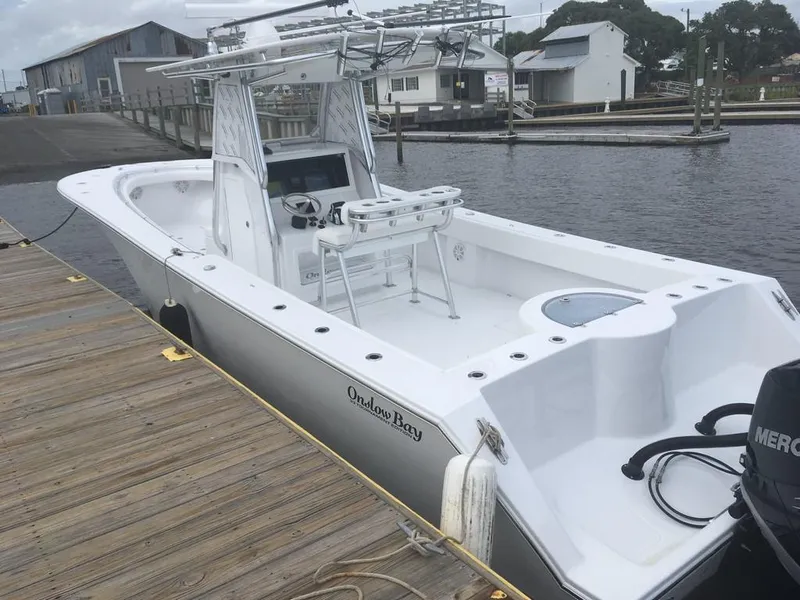 Slide: The Image of 2019 Onslow Bay 33 Tournament boat docked at a marina, showcasing sleek design and spacious deck. - 34