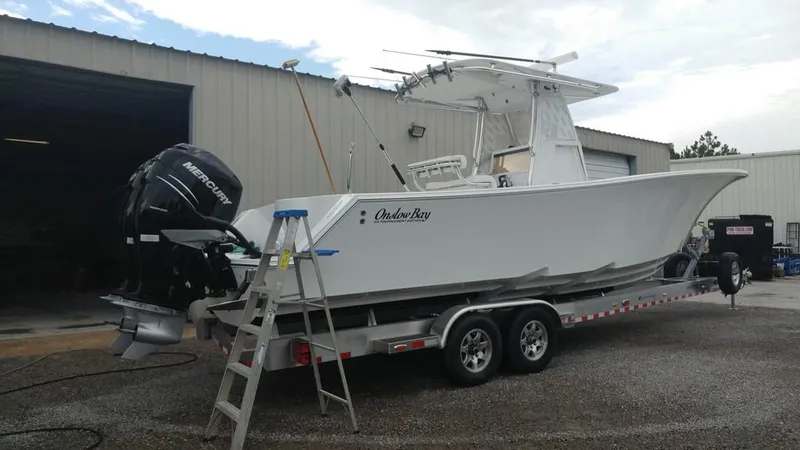 Slide: The Image of 2019 Onslow Bay 33 Tournament boat on trailer, parked outside a warehouse. - 37