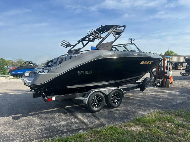 Slide: The Image of 2025 Yamaha Boats 222XD on trailer, sleek black design, parked outdoors. - 3
