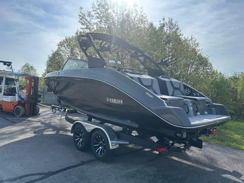 Slide: The Image of 2025 Yamaha Boats 222XD on trailer, sleek design, parked outdoors under clear sky. - 4