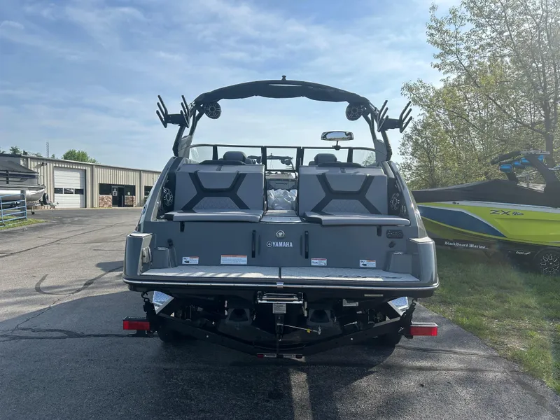 Slide: The Image of 2025 Yamaha Boats 222XD, rear view, parked outdoors on a sunny day. - 5