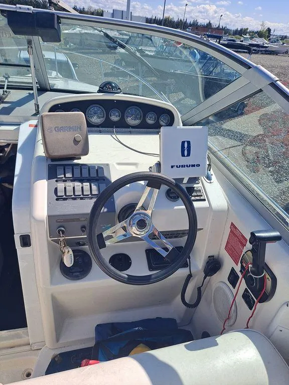 Slide: The Image of 1994 Sea Ray 270 Express boat dashboard with steering wheel and navigation equipment. - 10