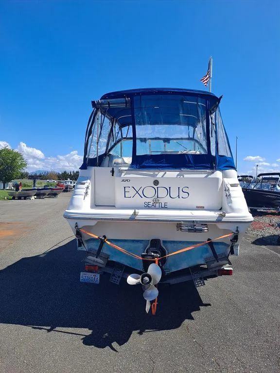 Slide: The Image of 1994 Sea Ray 270 Express boat, rear view, docked under clear blue sky. - 2