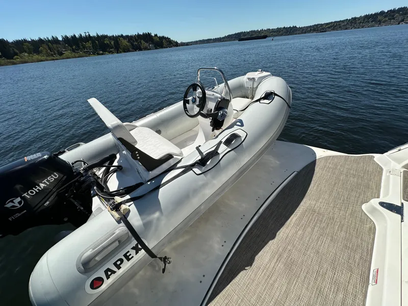 Slide: The Image of Apex inflatable boat with Tohatsu motor on Sea Ray 340 Sundancer, 2004 model, docked on a lake. - 11