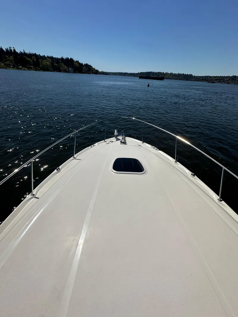 Slide: The Image of 2004 Sea Ray 340 Sundancer cruising on a sunny lake with clear blue skies. - 17