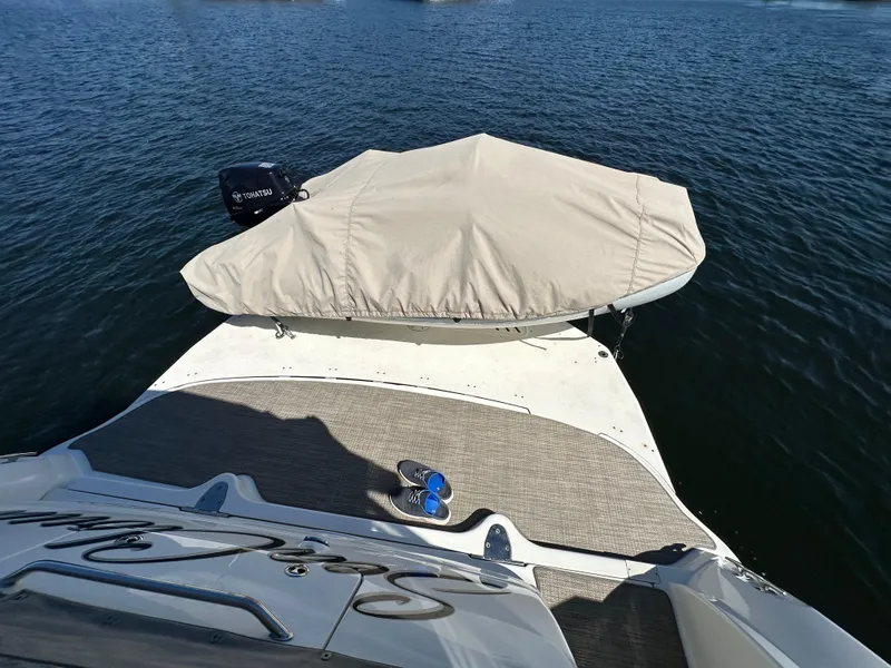 Slide: The Image of 2004 Sea Ray 340 Sundancer boat with covered outboard motor on calm water. - 20