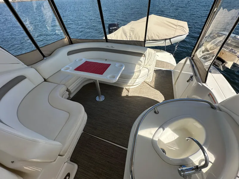 Slide: The Image of 2004 Sea Ray 340 Sundancer interior with seating, table, and sink, overlooking water. - 21