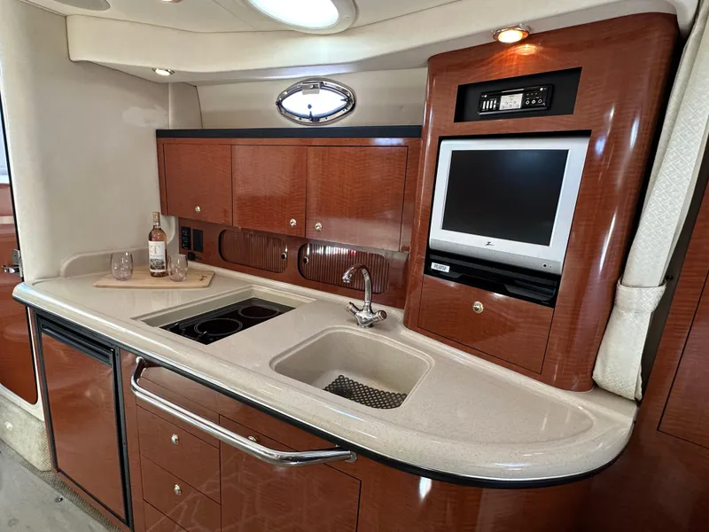Slide: The Image of 2004 Sea Ray 340 Sundancer interior with kitchenette, sink, and TV. - 38