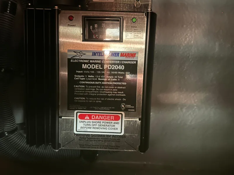 Slide: The Image of 2004 Sea Ray 340 Sundancer marine converter charger, model PD2040, with safety warning label. - 42