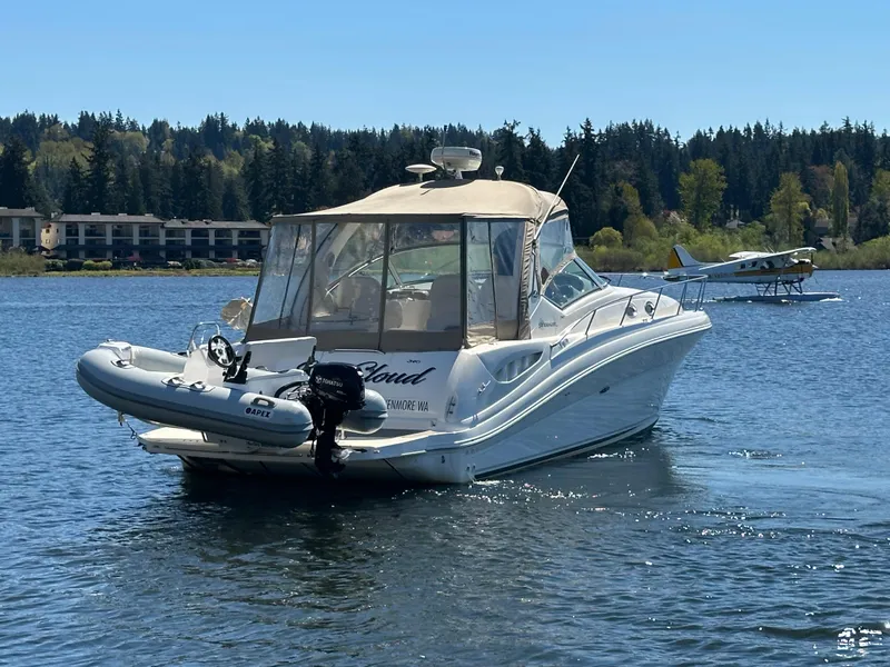 Slide: The Image of 2004 Sea Ray 340 Sundancer boat on a lake with a seaplane in the background. - 6
