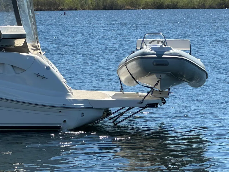 Slide: The Image of 2004 Sea Ray 340 Sundancer with dinghy on water, rear view. - 7