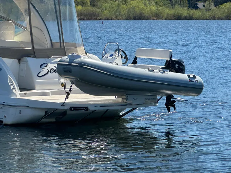 Slide: The Image of 2004 Sea Ray 340 Sundancer with inflatable dinghy on water, sunny day. - 9