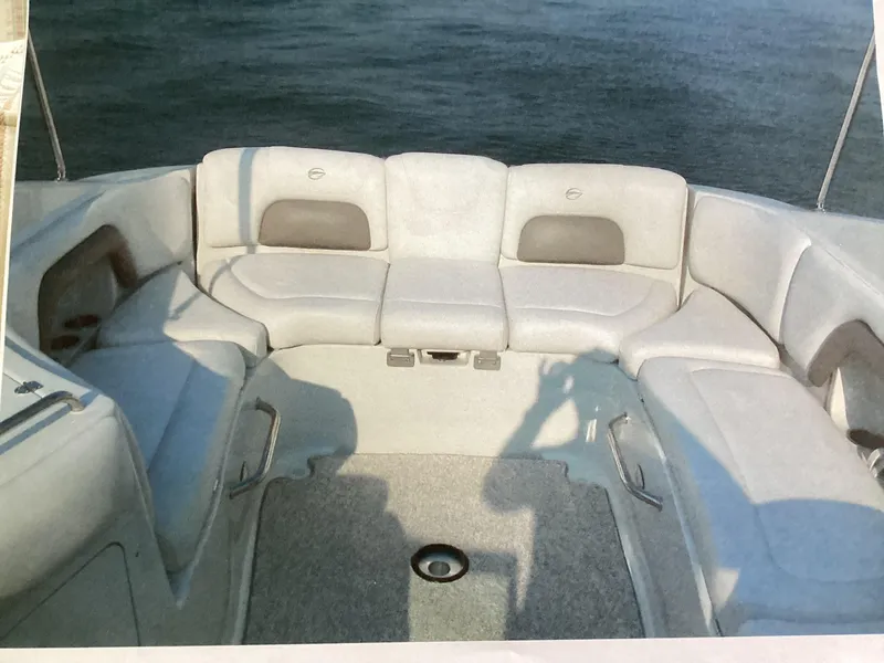 Slide: The Image of 2006 Crownline 270 BR boat interior with spacious seating and water backdrop. - 12