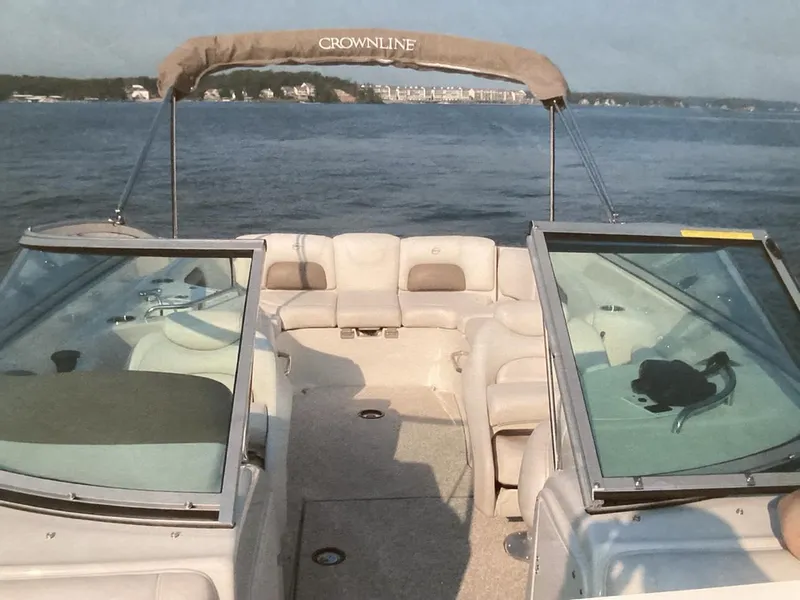 Slide: The Image of 2006 Crownline 270 BR boat with open deck, cruising on a scenic lake. - 3