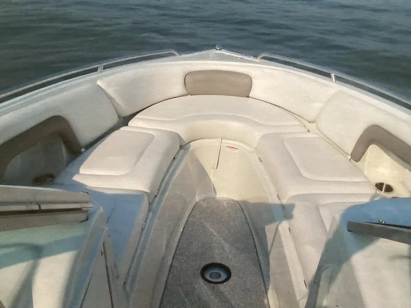 Slide: The Image of 2006 Crownline 270 BR boat interior with cushioned seating on calm water. - 8