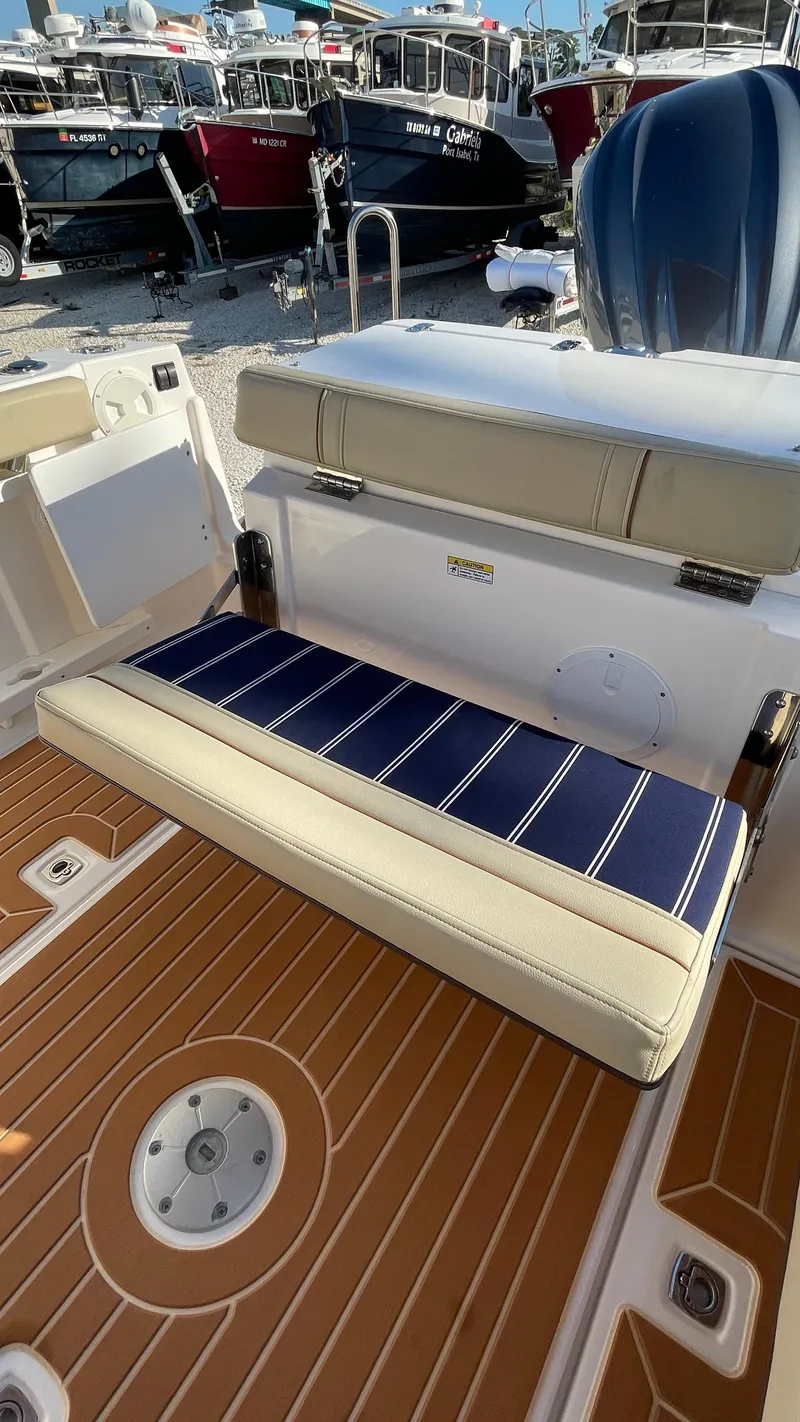 Slide: The Image of 2023 Ranger Tugs R-27 boat interior with cushioned seating and teak-style flooring. - 11