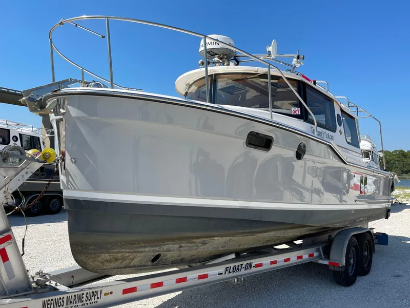 Slide: The Image of 2023 Ranger Tugs R-27 boat on trailer, side view, outdoors. - 2