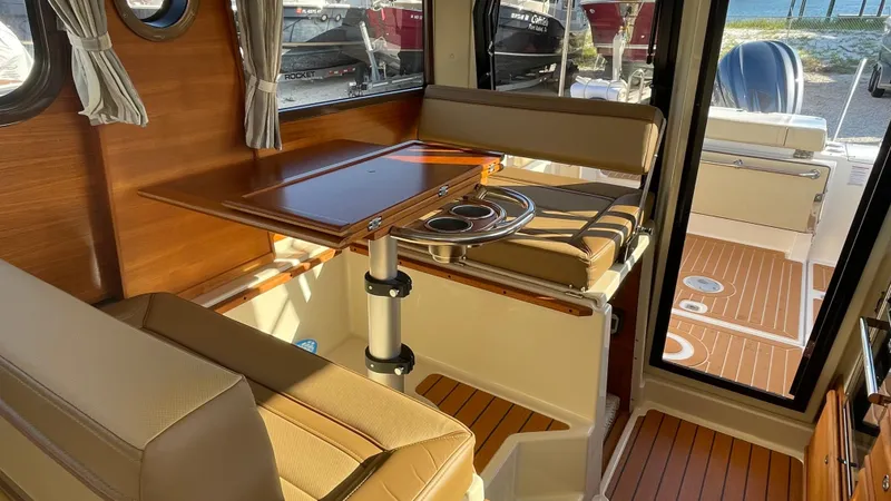 Slide: The Image of 2023 Ranger Tugs R-27 interior with wood accents and seating area. - 22