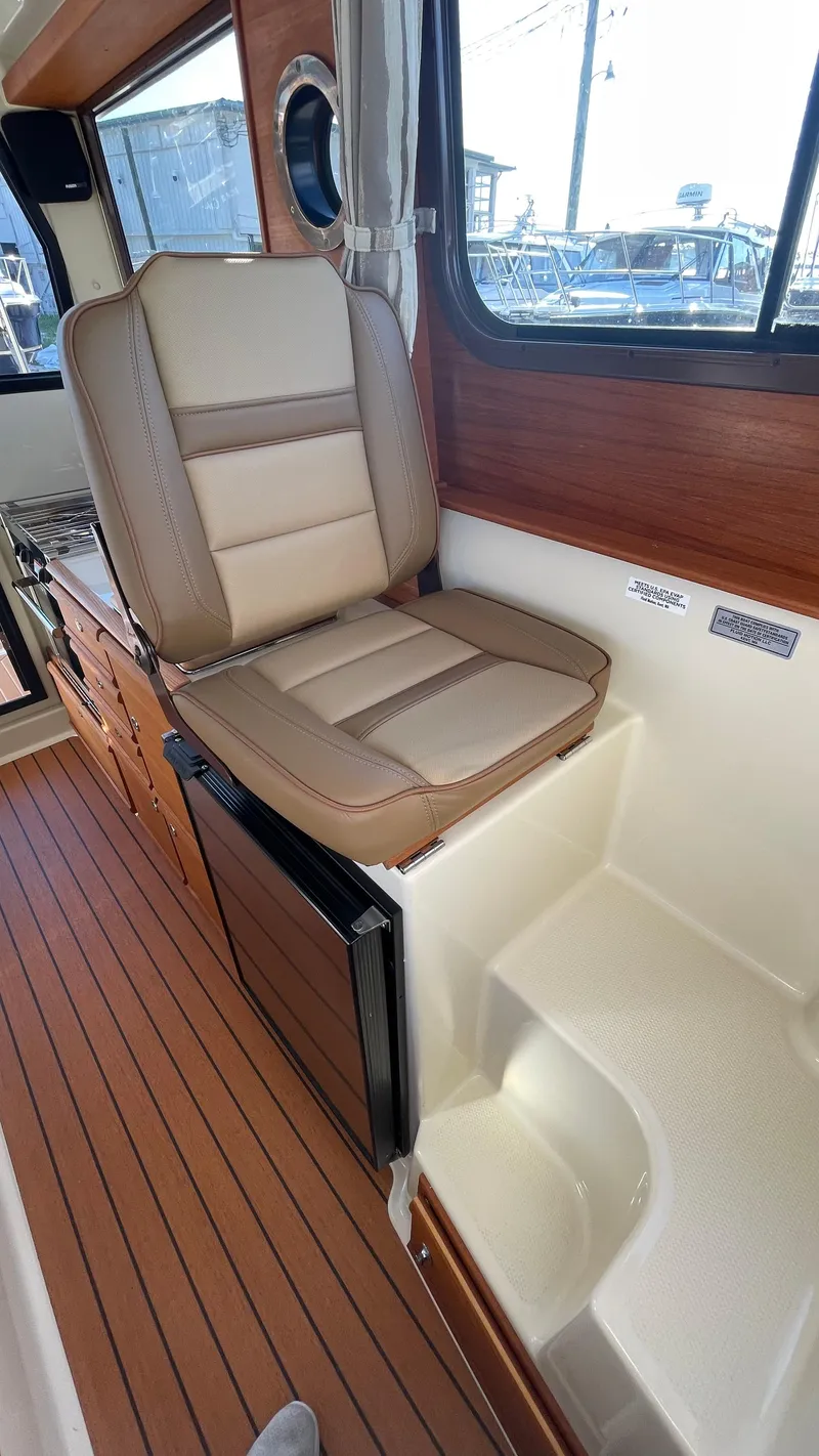 Slide: The Image of 2023 Ranger Tugs R-27 interior with cushioned seating and wood accents. - 28