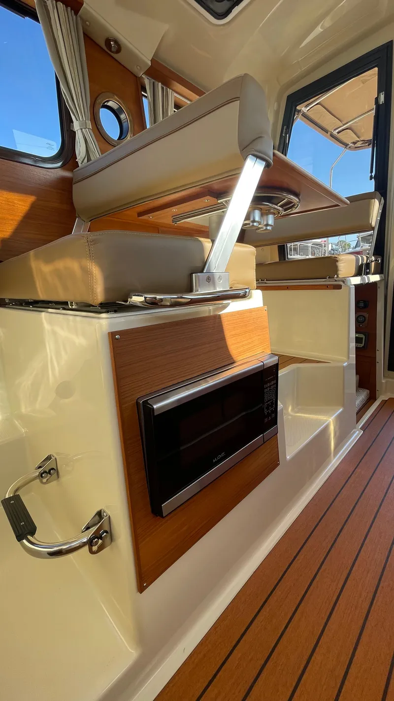 Slide: The Image of 2023 Ranger Tugs R-27 interior with wood accents and modern amenities. - 32