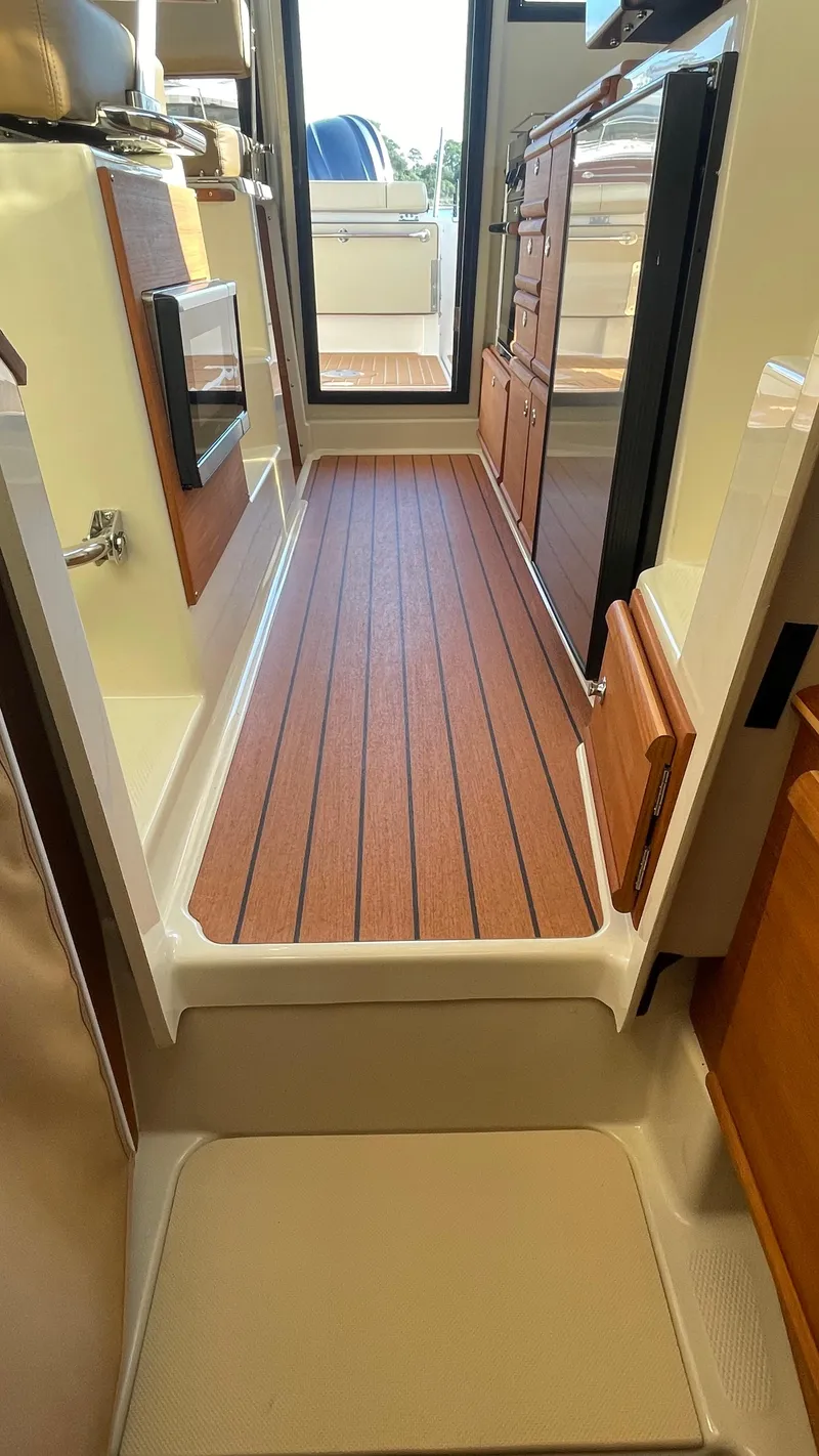 Slide: The Image of 2023 Ranger Tugs R-27 interior with wood flooring and modern cabinetry. - 38