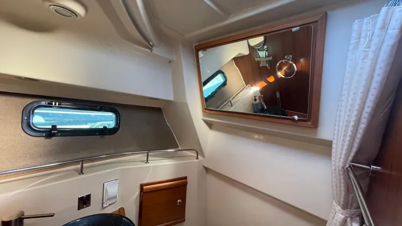 Slide: The Image of Interior cabin of 2023 Ranger Tugs R-27 with window, mirror, and wooden accents. - 41