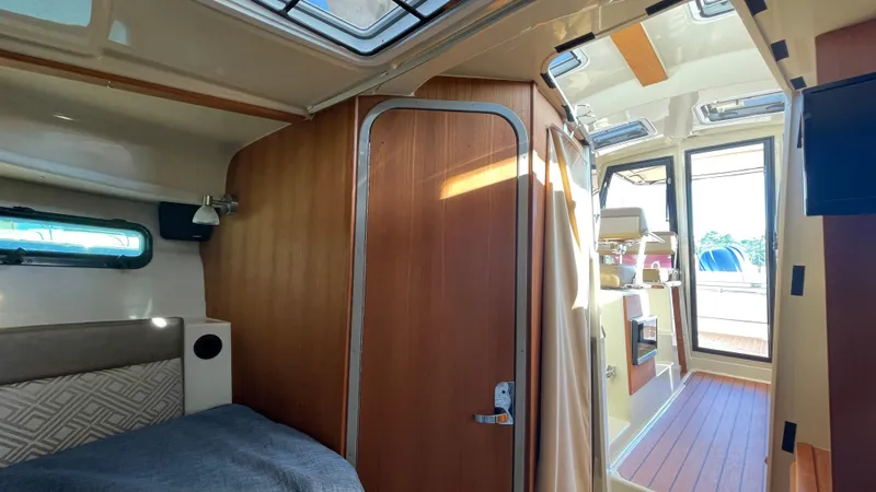 Slide: The Image of 2023 Ranger Tugs R-27 interior cabin with wood finishes and natural light. - 42