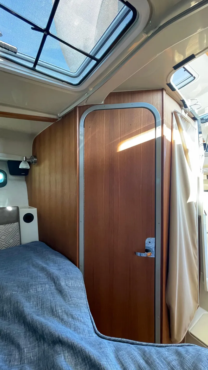 Slide: The Image of Interior of 2023 Ranger Tugs R-27, featuring a wooden door and cozy cabin space. - 43