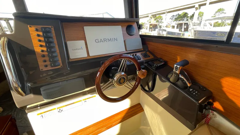 Slide: The Image of 2023 Ranger Tugs R-27 helm with Garmin navigation system and wooden steering wheel. - 45
