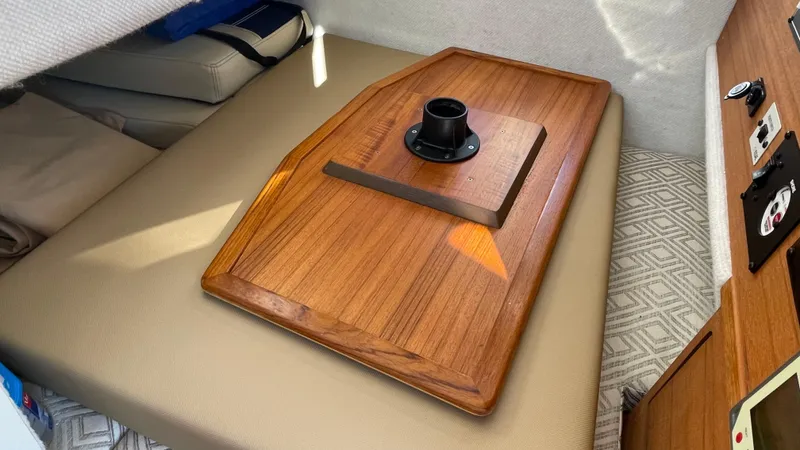 Slide: The Image of Interior of 2023 Ranger Tugs R-27 boat with wooden table and beige seating. - 48