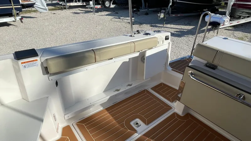 Slide: The Image of 2023 Ranger Tugs R-27 boat interior with cushioned seating and wood-patterned flooring. - 7