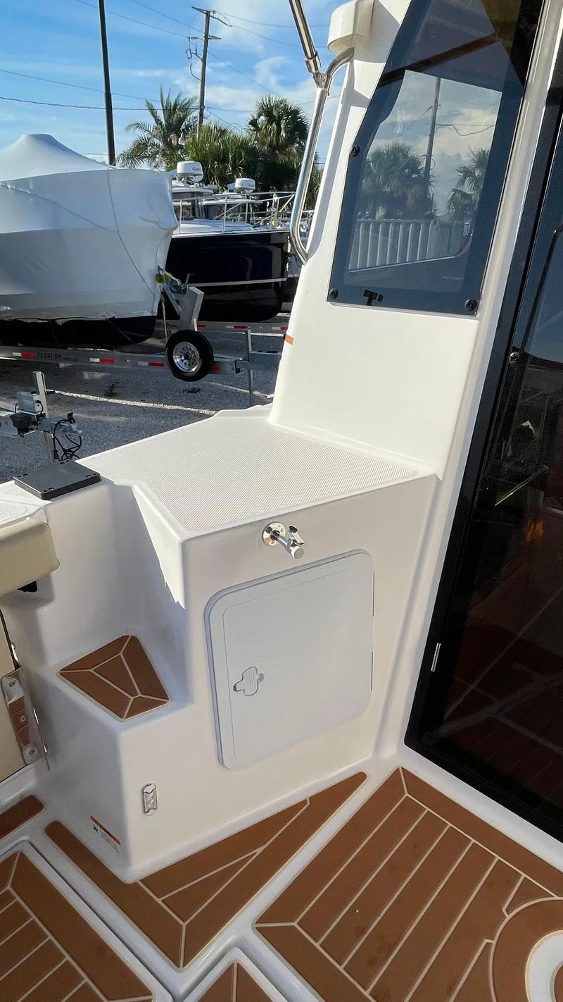 Slide: The Image of 2023 Ranger Tugs R-27 boat deck with storage compartment and seating area. - 8