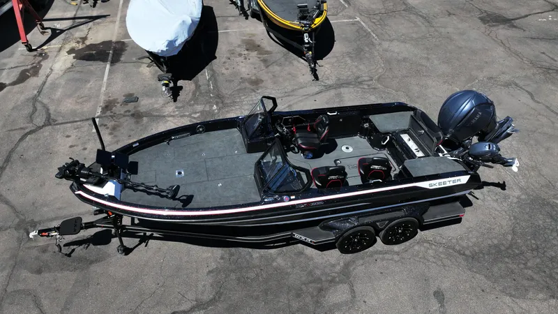 Slide: The Image of 2025 Skeeter WXR2260 boat on trailer, parked outdoors, featuring sleek design and modern equipment. - 2