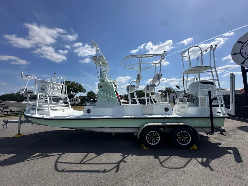 Slide: The Image of 2023 Shallow Master 240 SMS boat on trailer under clear blue sky. - 11