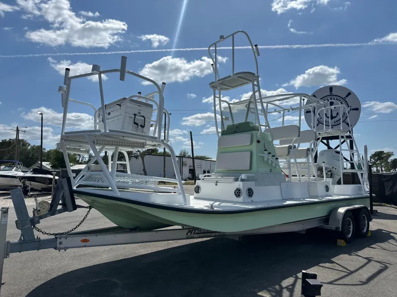 Slide: The Image of 2023 Shallow Master 240 SMS boat on trailer under sunny sky. - 12