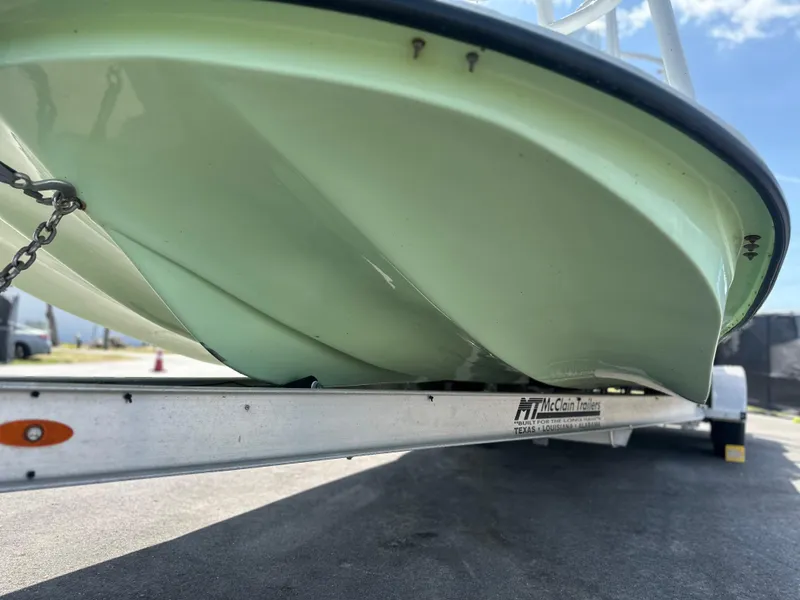 Slide: The Image of 2023 Shallow Master 240 SMS boat on trailer, showcasing hull design. - 14