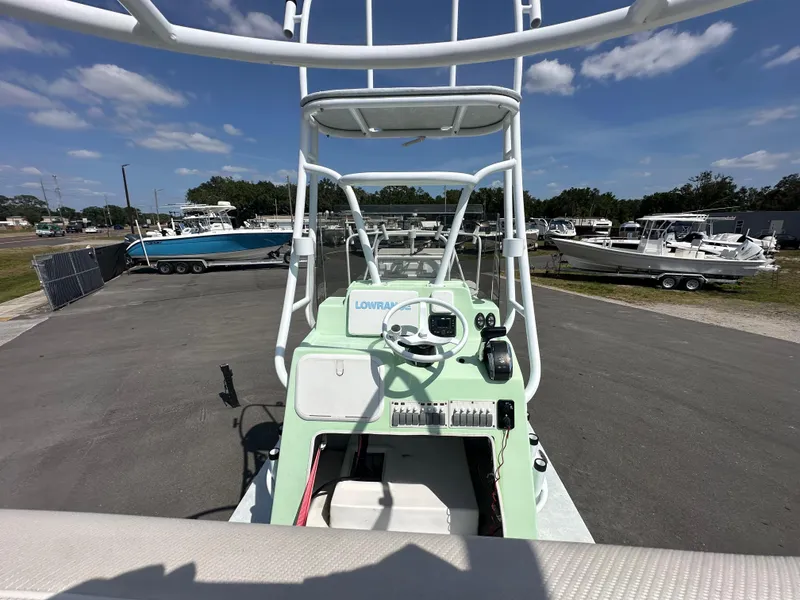 Slide: The Image of 2023 Shallow Master 240 SMS boat with tower, parked in a marina under a clear sky. - 18