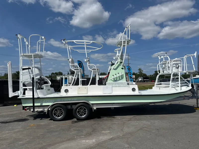 Slide: The Image of 2023 Shallow Master 240 SMS boat on trailer under blue sky. - 2