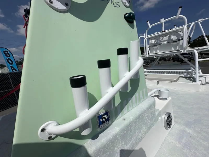 Slide: The Image of Fishing rod holders on a 2023 Shallow Master 240 SMS boat under a clear sky. - 21