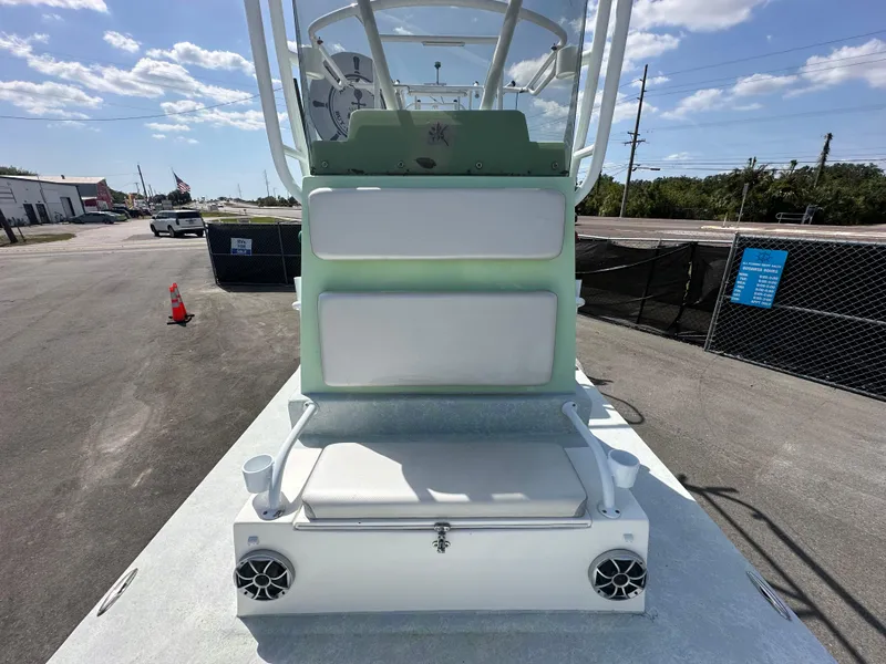 Slide: The Image of 2023 Shallow Master 240 SMS boat with seating and speakers, parked outdoors under a clear sky. - 26