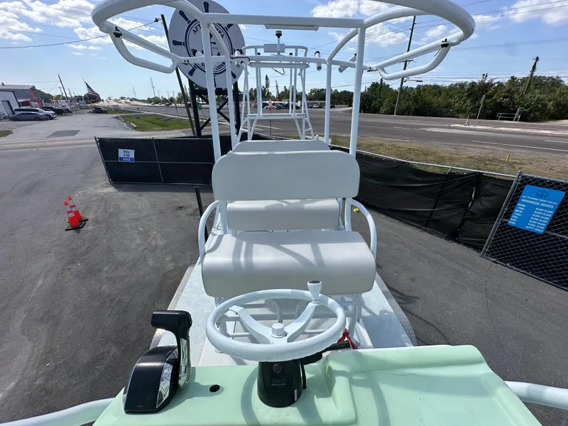 Slide: The Image of 2023 Shallow Master 240 SMS boat with elevated seating and steering wheel, parked outdoors. - 30