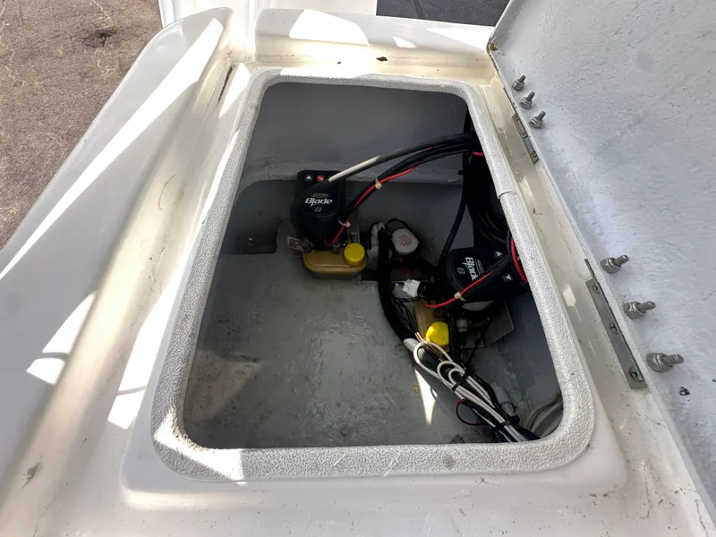 Slide: The Image of Open compartment of 2023 Shallow Master 240 SMS boat showing wiring and components. - 35