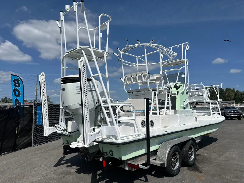 Slide: The Image of 2023 Shallow Master 240 SMS boat on trailer, featuring elevated towers and outboard motor. - 4